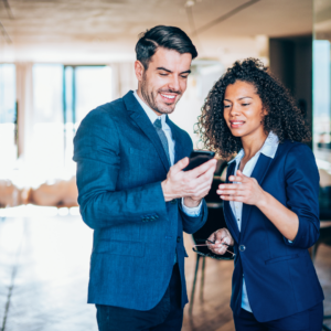 Two financial advisors speaking while looking at a phone
